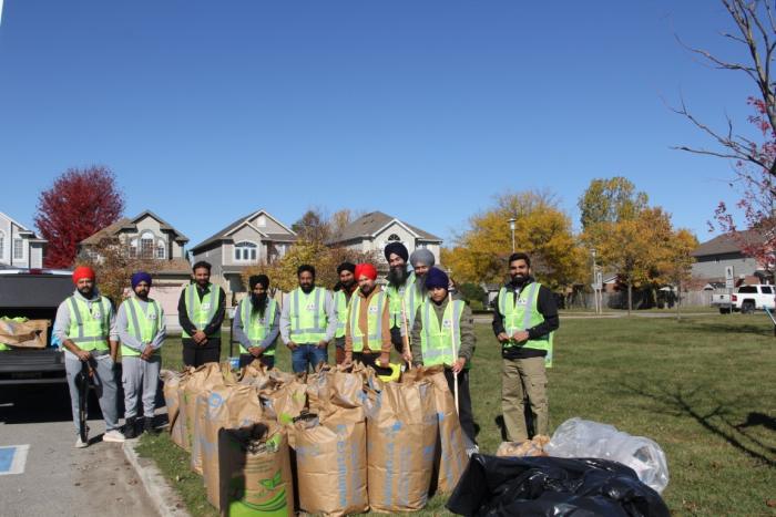 Volunteers behind rows of filled yard-waste bags after a park clean-up