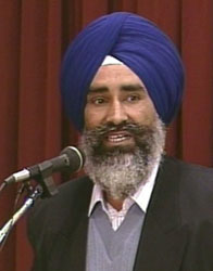 Portrait of Bhai Jaswant Singh Khalra speaking at a microphone