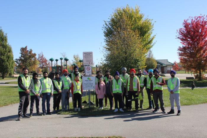 Club volunteers gathered at the Adopt-a-Park sign at Meadowgate Park